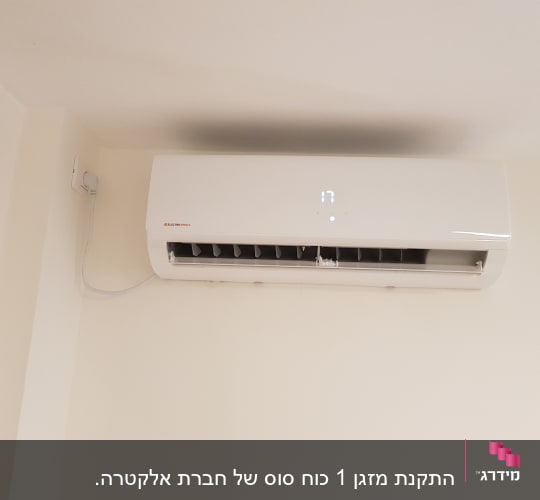 מזגן קיר לבן מותקן על קיר עם תצוגה דיגיטלית